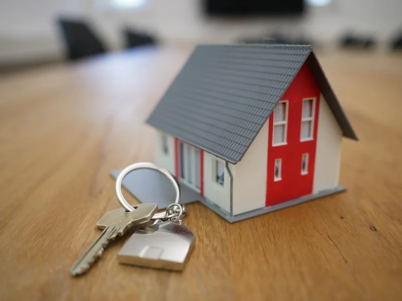 Immobilienverkauf – Hausmodell mit Schlüsseln